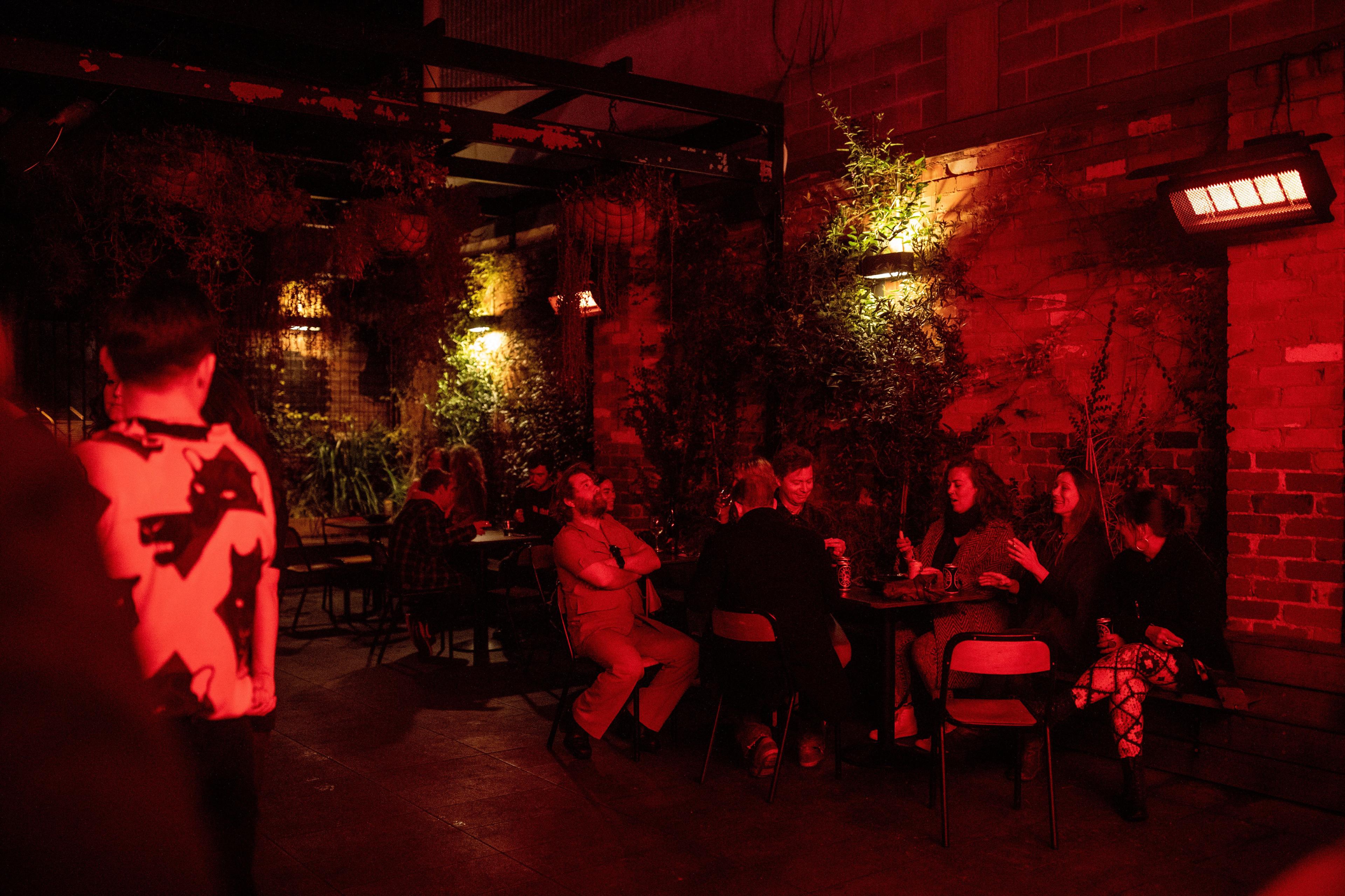 Several people outside in the Altar Bar smoking area.