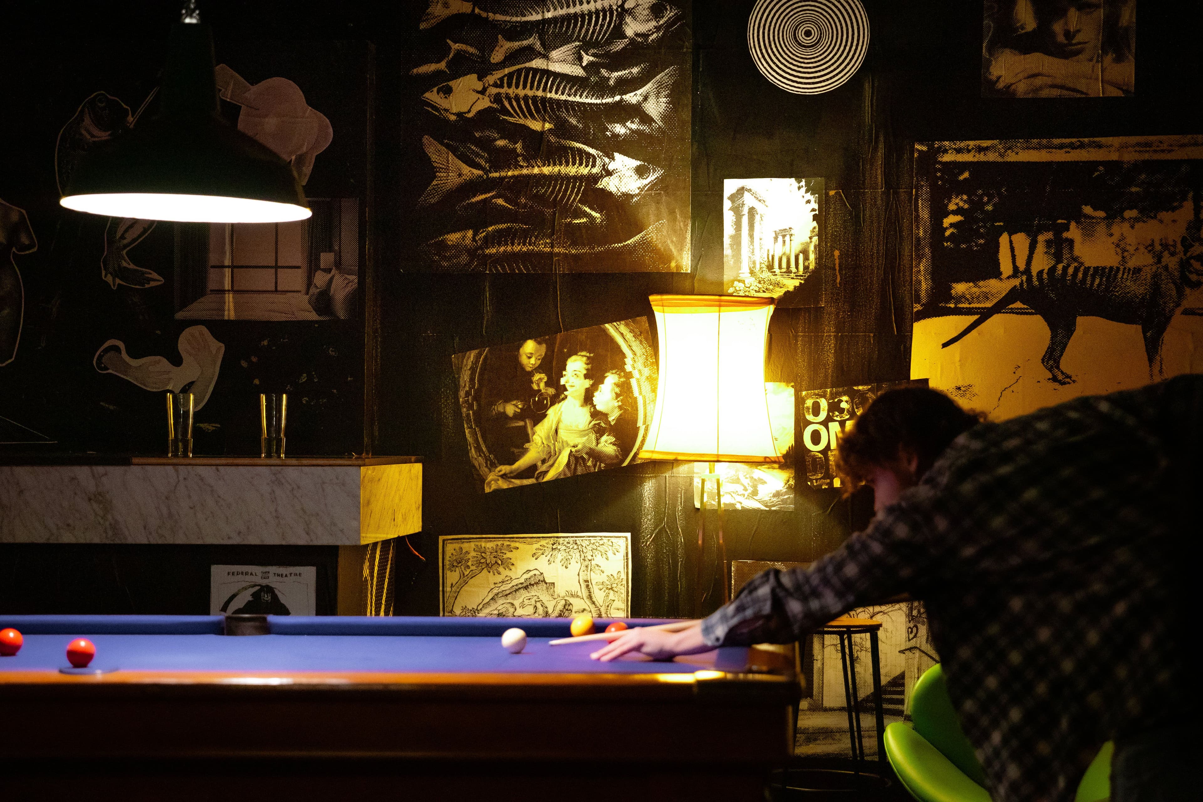 A person plays pool on a purple pool table.